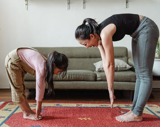 mum and daughter stretching together at home 